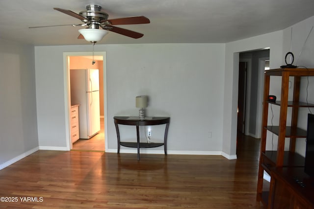 interior space featuring baseboards, ceiling fan, and wood finished floors