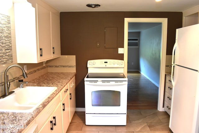 kitchen with white cabinets, a sink, white appliances, light countertops, and light tile patterned floors