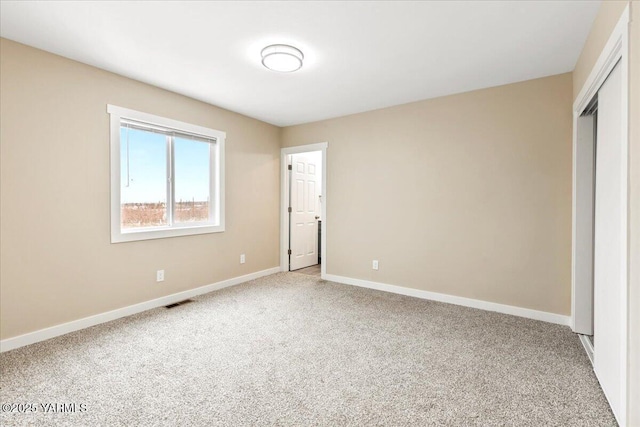 unfurnished bedroom featuring carpet, a closet, visible vents, and baseboards