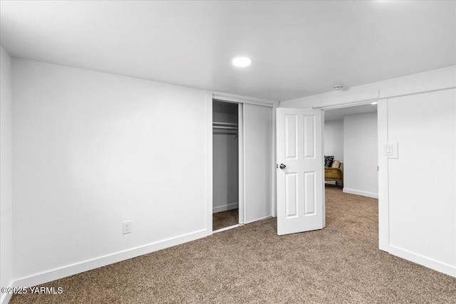 unfurnished bedroom with carpet, baseboards, and a closet