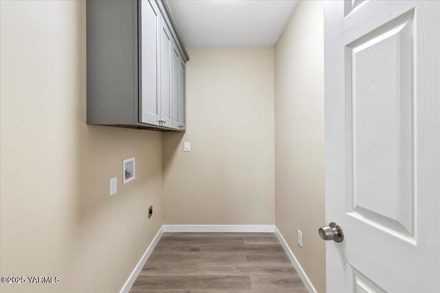 laundry area with light wood finished floors, hookup for a washing machine, cabinet space, and baseboards