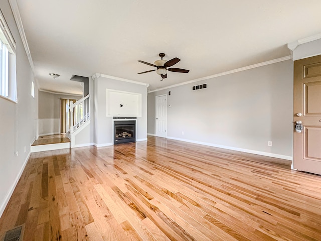 unfurnished living room featuring ornamental molding, ceiling fan, and light wood-type flooring