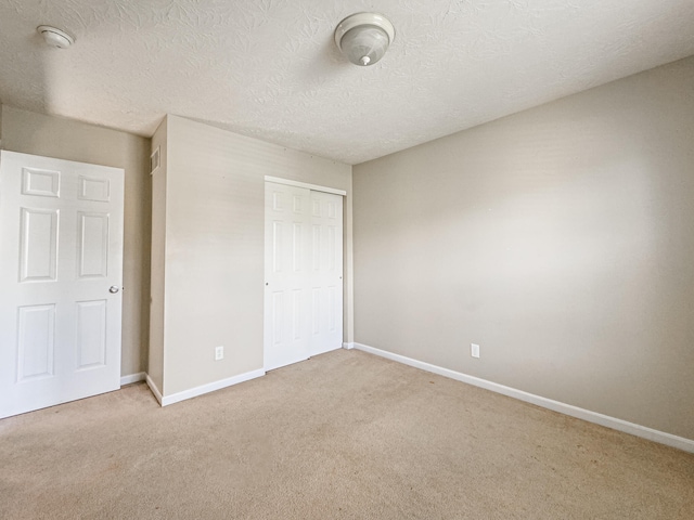 unfurnished bedroom with a closet, carpet, and a textured ceiling