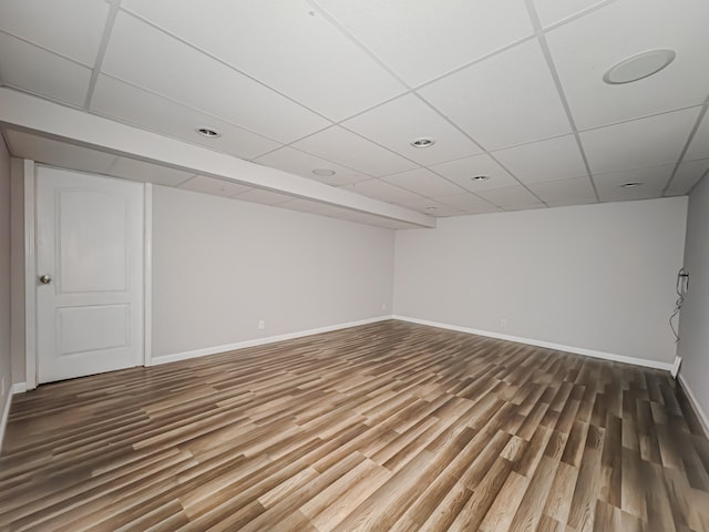 unfurnished room featuring wood-type flooring and a paneled ceiling