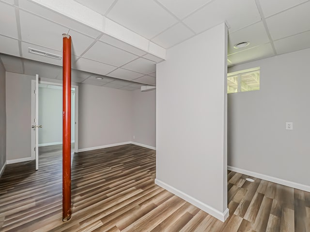 basement featuring hardwood / wood-style flooring and a paneled ceiling