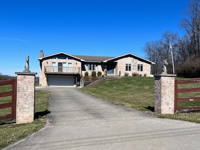 view of front of property with a balcony, a front yard, and a garage