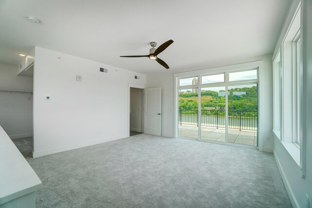 empty room featuring ceiling fan and light carpet