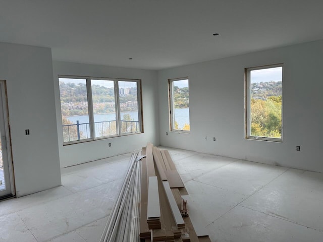 empty room with a wealth of natural light and a water view