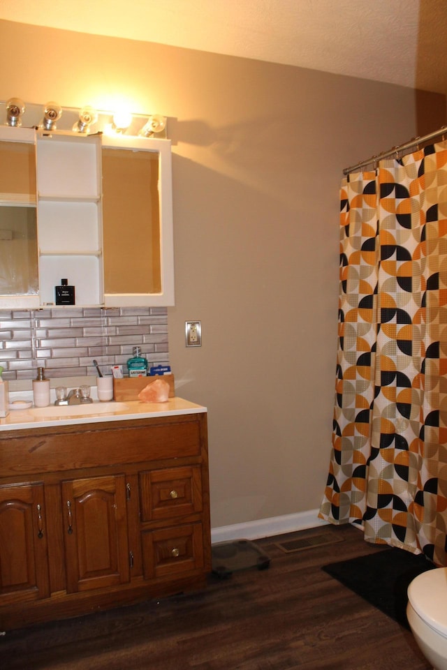 bathroom featuring backsplash, vanity, toilet, hardwood / wood-style floors, and a shower with curtain