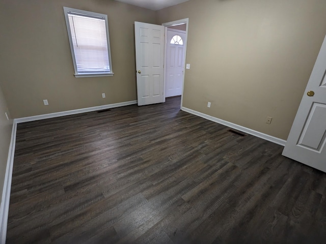 unfurnished bedroom with dark hardwood / wood-style floors