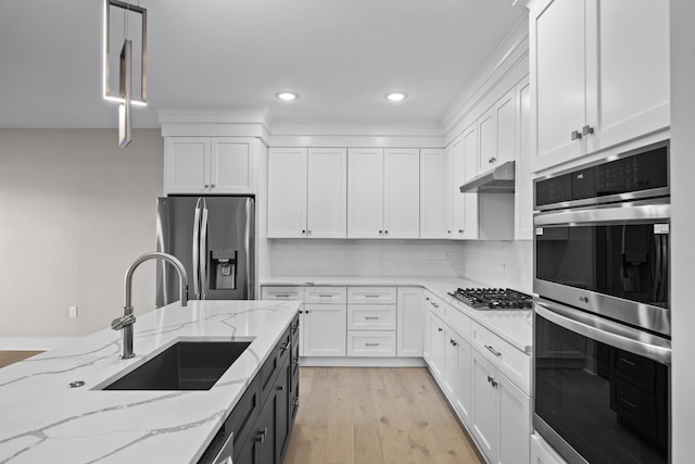 kitchen featuring appliances with stainless steel finishes, sink, and white cabinetry