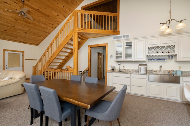 dining room featuring light colored carpet, wooden ceiling, sink, and high vaulted ceiling