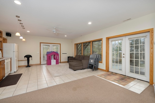 living room with plenty of natural light, ceiling fan, light tile patterned floors, and french doors