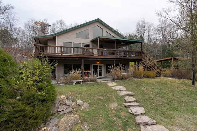 rear view of house featuring a lawn and a wooden deck