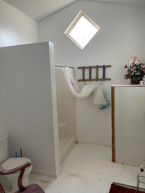 full bath featuring baseboards, toilet, a stall shower, and a textured ceiling