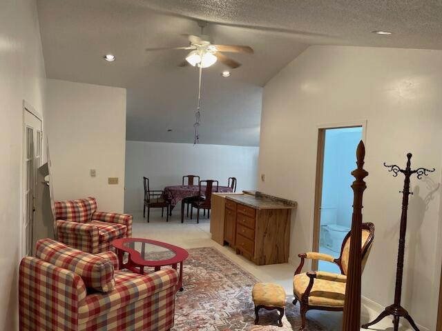 sitting room with a ceiling fan, recessed lighting, vaulted ceiling, a textured ceiling, and light colored carpet