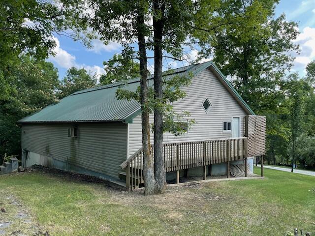 view of side of home featuring a yard and a deck