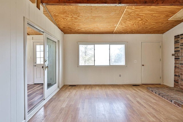 empty room with wood ceiling, brick wall, light hardwood / wood-style floors, and vaulted ceiling