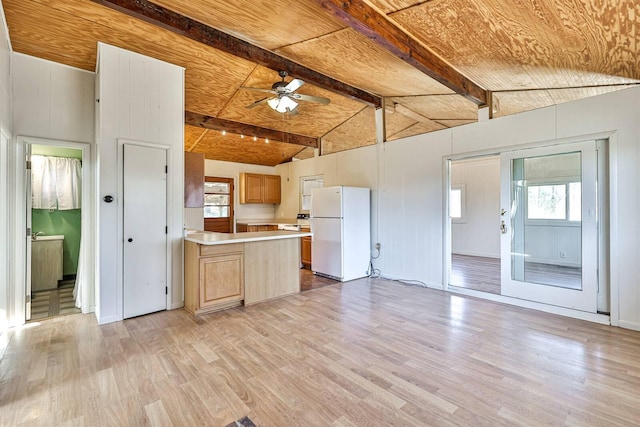 kitchen featuring white fridge, ceiling fan, light hardwood / wood-style flooring, a wealth of natural light, and lofted ceiling with beams