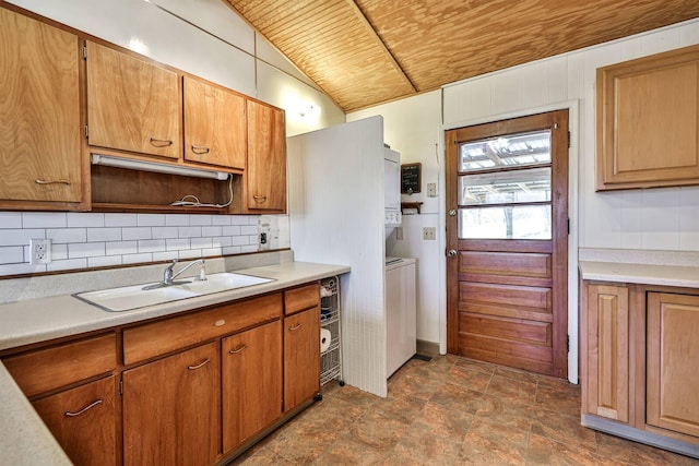 kitchen featuring backsplash, sink, stacked washer and clothes dryer, vaulted ceiling, and wood ceiling