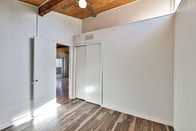 unfurnished bedroom featuring ceiling fan, hardwood / wood-style floors, wood ceiling, beam ceiling, and a closet