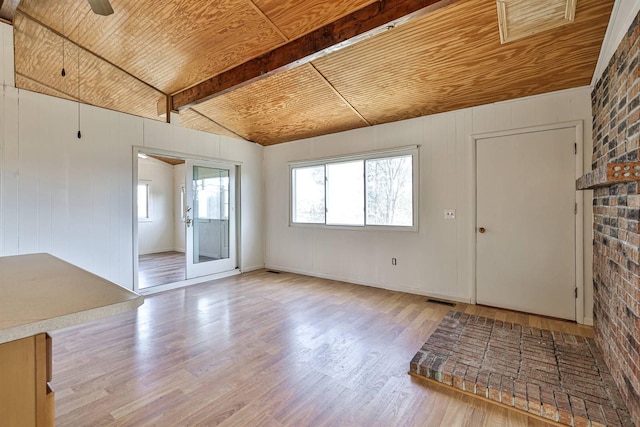 empty room with vaulted ceiling with beams, light hardwood / wood-style floors, ceiling fan, and wooden ceiling