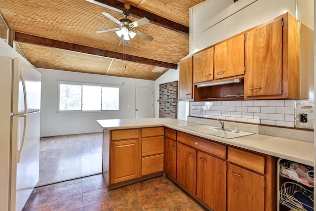 kitchen featuring vaulted ceiling with beams, white fridge, ceiling fan, kitchen peninsula, and backsplash