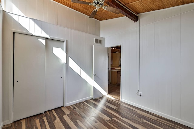 spare room featuring ceiling fan, a towering ceiling, wood ceiling, dark wood-type flooring, and beam ceiling