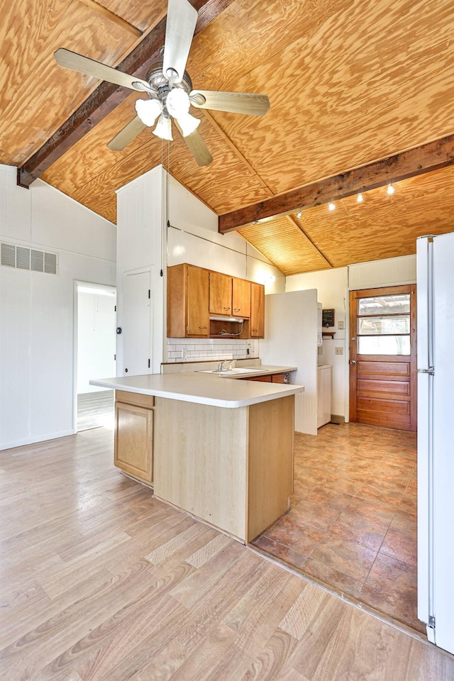 kitchen featuring vaulted ceiling with beams, white fridge, ceiling fan, tasteful backsplash, and light wood-type flooring