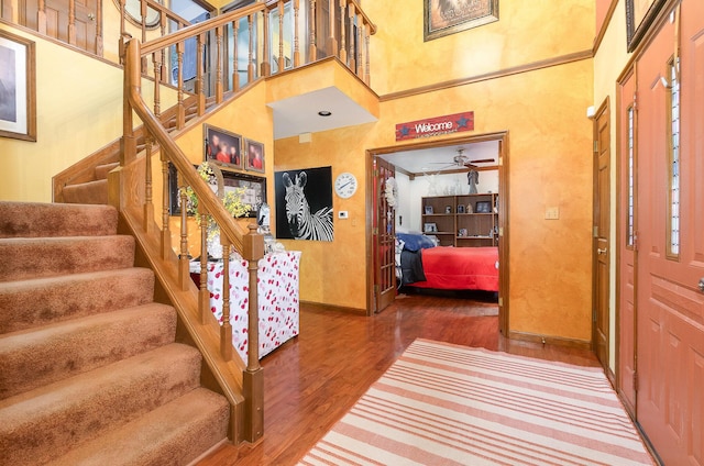 8104 Harms Hill Dr, Florence, KY 41042 - foyer featuring wood finished floors, baseboards, stairs, a towering ceiling, and a ceiling fan