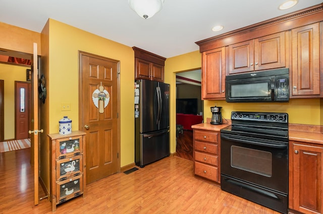 8104 Harms Hill Dr, Florence, KY 41042 - kitchen with black appliances, light wood-style floors, light countertops, and brown cabinets