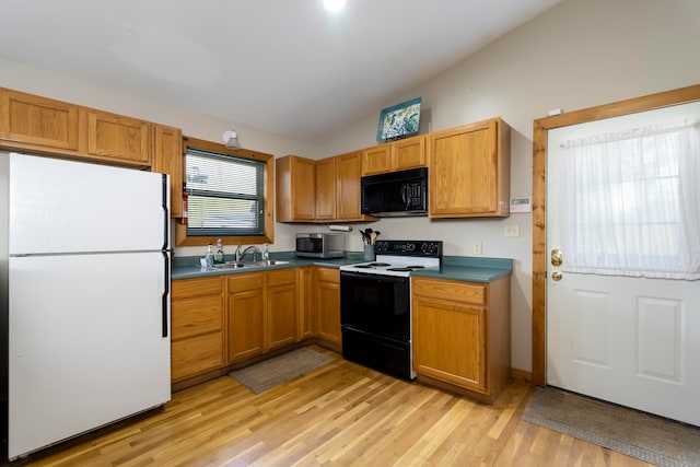 kitchen featuring white appliances, sink, light wood-type flooring, and vaulted ceiling