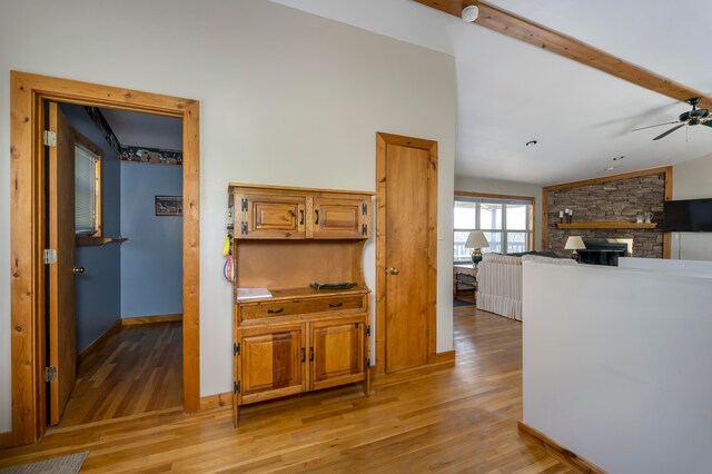 interior space featuring vaulted ceiling with beams and light hardwood / wood-style flooring