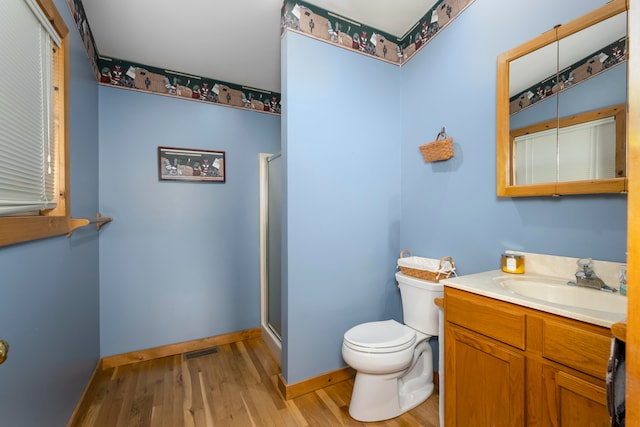 bathroom featuring an enclosed shower, toilet, hardwood / wood-style floors, and vanity with extensive cabinet space