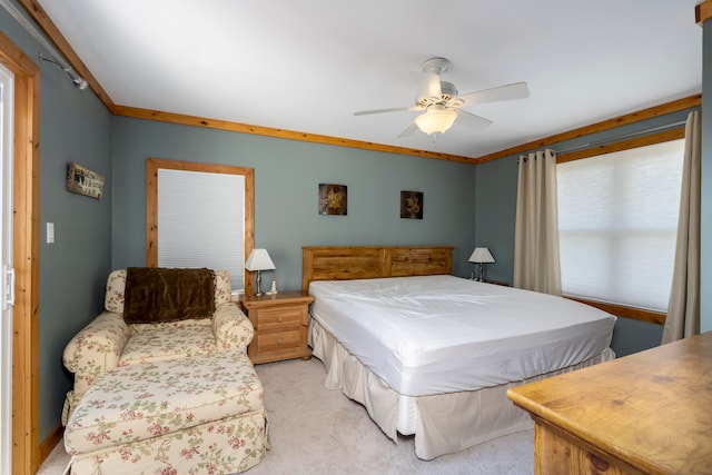 bedroom with crown molding, light colored carpet, and ceiling fan