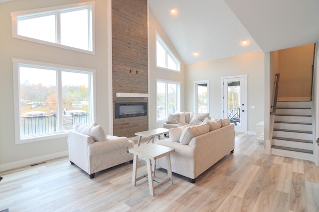 465 Cedar Hill Dr, Williamstown, KY 41097 - living room with high vaulted ceiling, baseboards, a large fireplace, stairway, and light wood-style floors