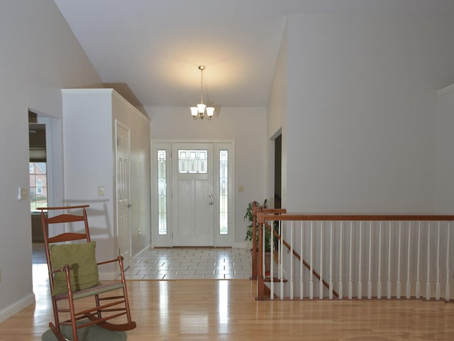 entrance foyer with light tile floors, high vaulted ceiling, and an inviting chandelier