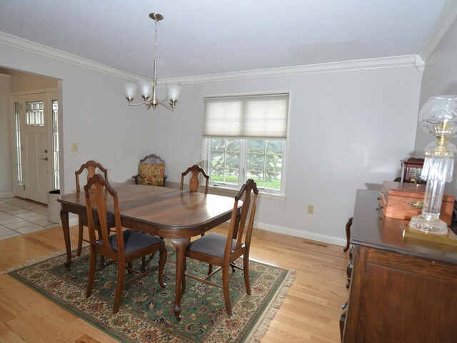 tiled dining space with an inviting chandelier and crown molding