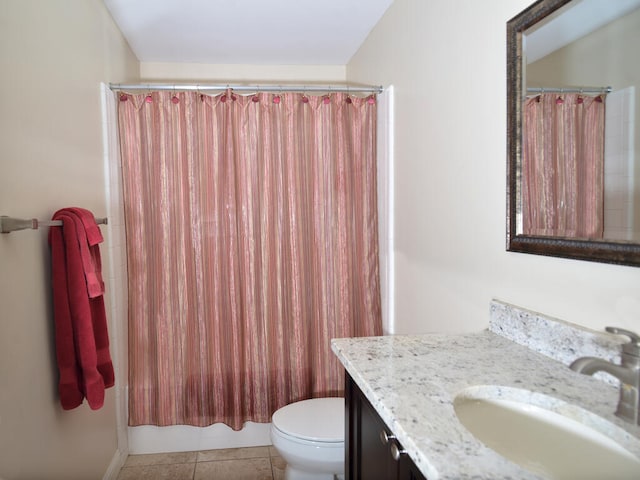 bathroom with toilet, tile floors, and vanity with extensive cabinet space