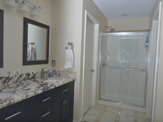 bathroom with double sink, tile floors, oversized vanity, and a shower with shower door