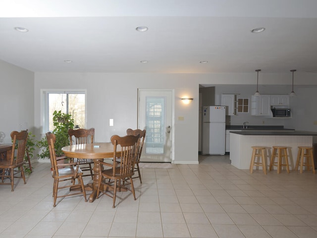 dining space with sink and light tile floors