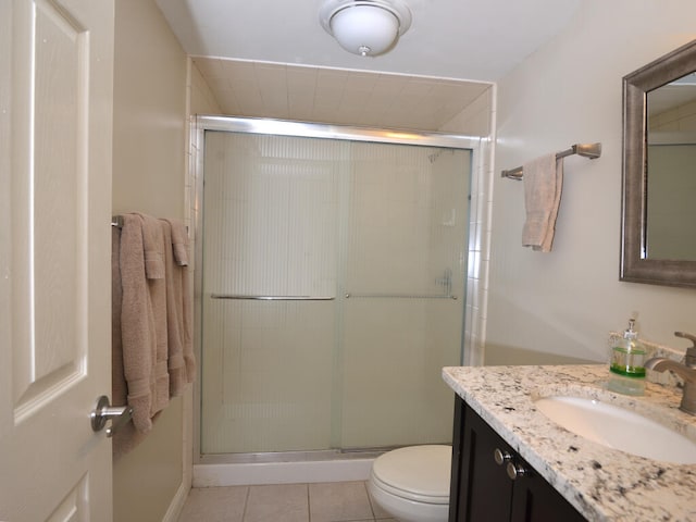 bathroom featuring vanity, tile floors, a shower with shower door, and toilet