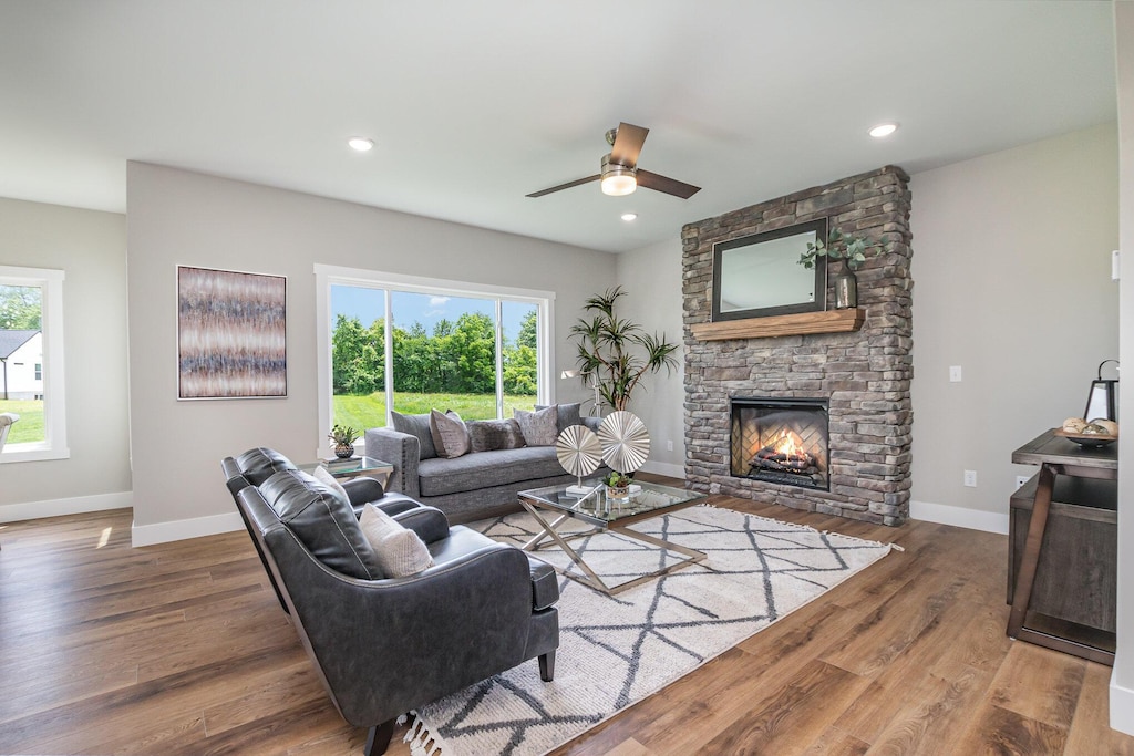 living room featuring recessed lighting, a fireplace, wood finished floors, and baseboards