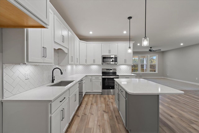 kitchen with light stone countertops, appliances with stainless steel finishes, sink, light hardwood / wood-style flooring, and white cabinets