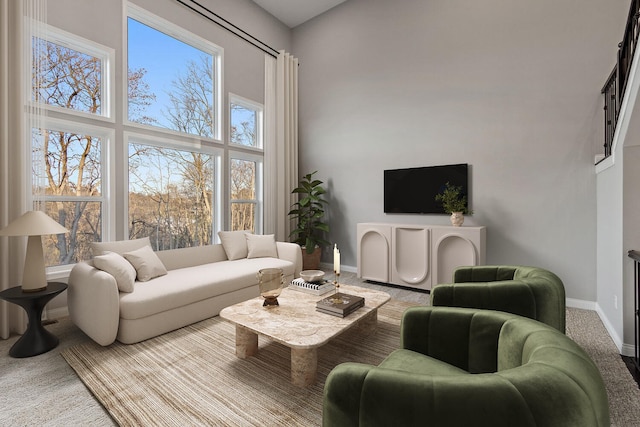 carpeted living room with a towering ceiling