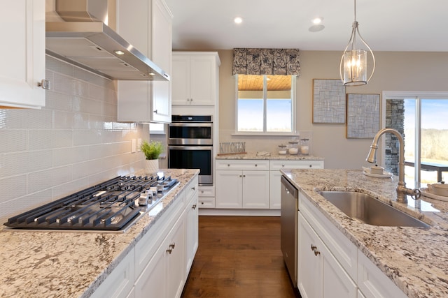 kitchen with wall chimney exhaust hood, sink, backsplash, stainless steel appliances, and dark hardwood / wood-style floors