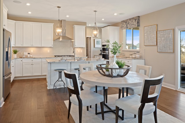 dining room with a healthy amount of sunlight, dark hardwood / wood-style flooring, and sink