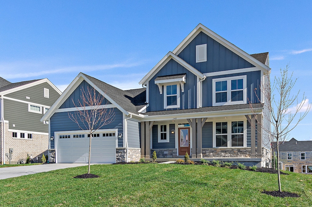 craftsman-style home with a garage, covered porch, and a front yard