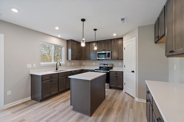 kitchen with stainless steel appliances, sink, light hardwood / wood-style flooring, a center island, and hanging light fixtures