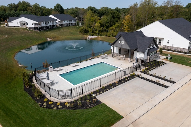 community pool with a yard, a water view, fence, and a patio